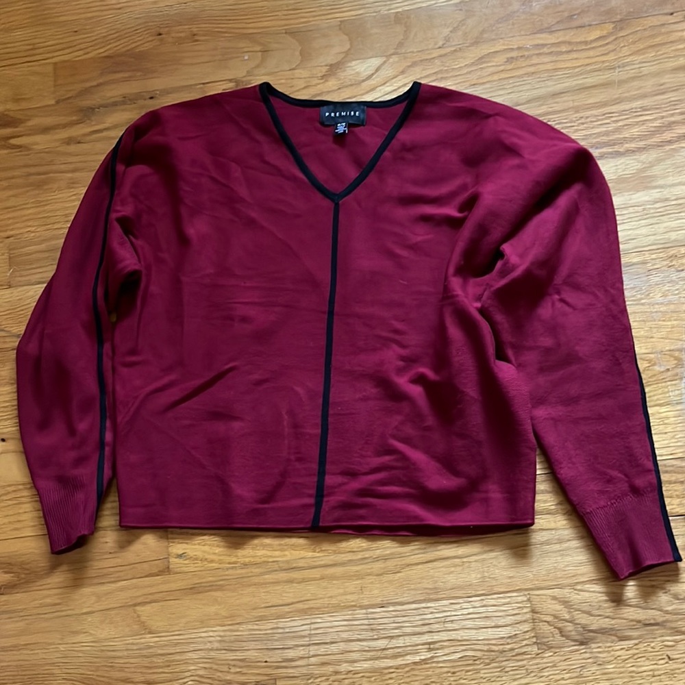 Red sweater w/ black trim down front, shoulders and each arm of the sweater M